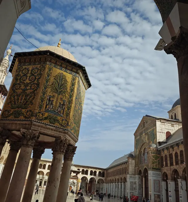 The courtyard of the Omayyad Mosque in Damascus, seen between two stone columns