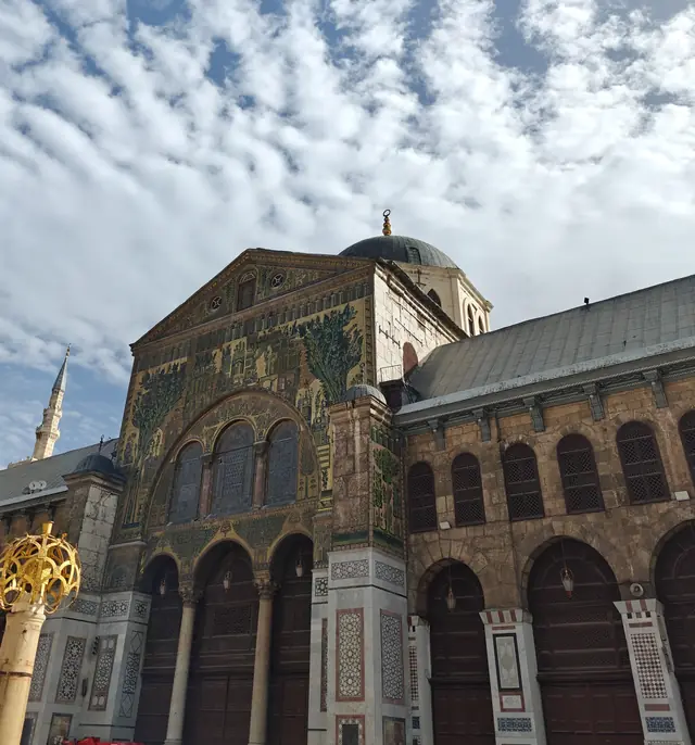 The gold and green mosaic facade and dome of the Omayyad Mosque in Damascus